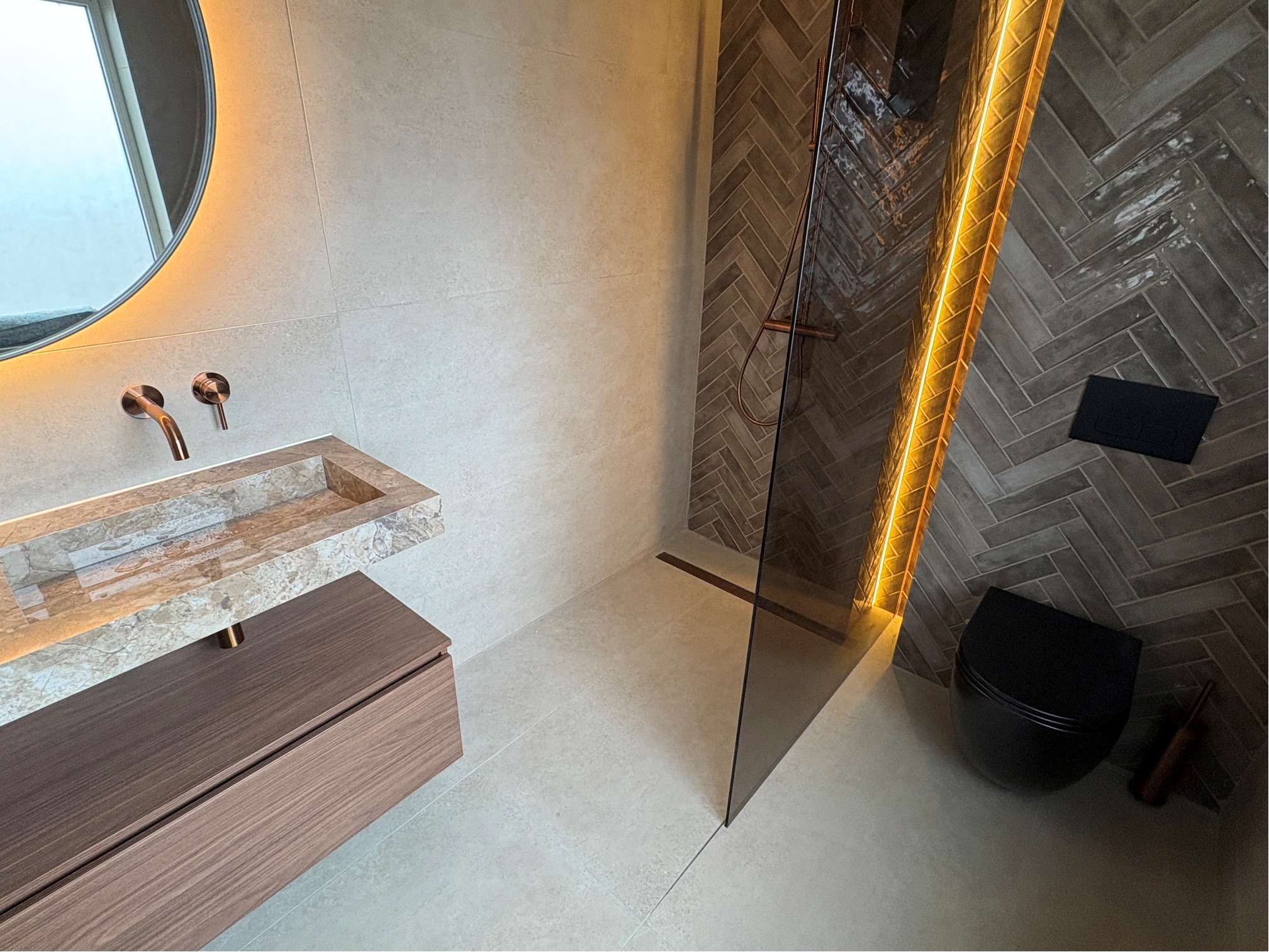 Overzicht van de luxe badkamer met wasmeubel, douche en toilet