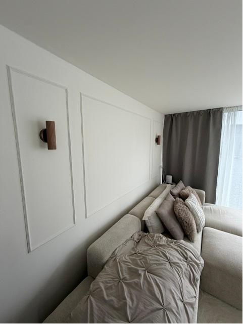 Warme zithoek met wandlijsten en wandverlichting