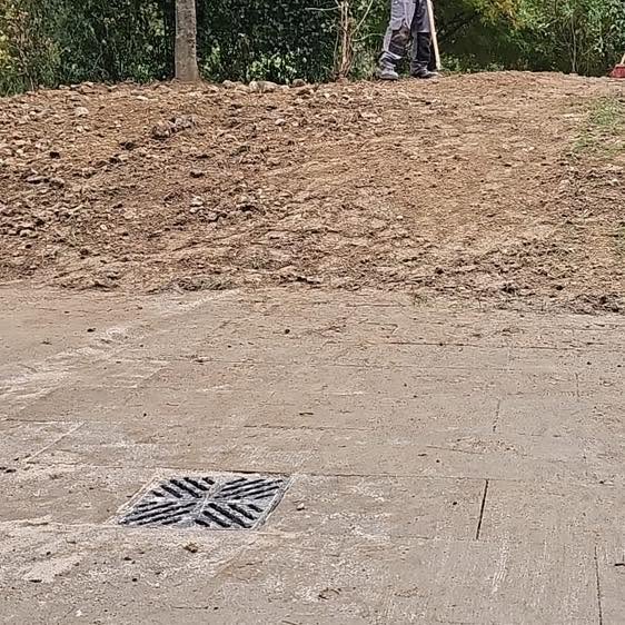 Afvoerput en opnieuw aangevuld en geëgaliseerd terrein